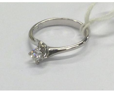 A small diamond single stone ring in 18 carat claw mount. Approx. 2.7 grams. Est. £80 - £120.