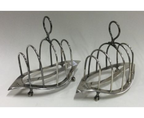 A pair of silver toast racks. London 1902. By William Hutton & Sons. Approx. 177 grams. Est. £140 - £160.