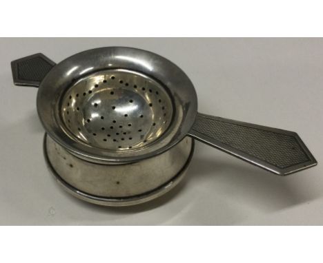 An Art Deco silver tea strainer on stand. Birmingham 1959. By S&M. Approx. 55 grams. Est. £100 - £150.