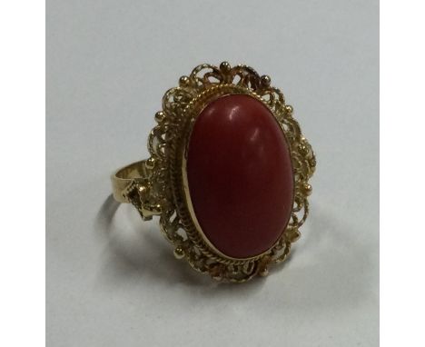 A heavy 18 carat gold coral mounted ring. Approx. 7.3 grams. Est. £180 - £220.