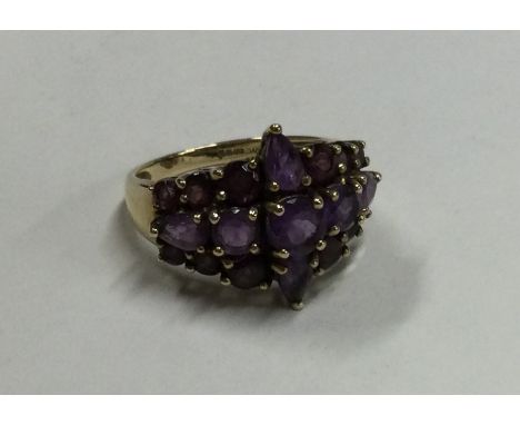 A large amethyst three row ring in 9 carat setting. Approx. 4.5 grams. Est. £60 - £80.