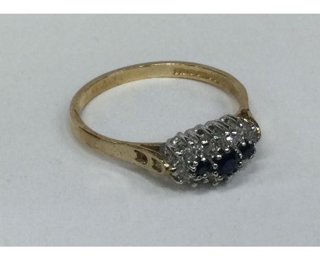 A good sapphire and diamond oval cluster ring in gold mount. Approx. 1.8 grams. Est. £60 - £80.