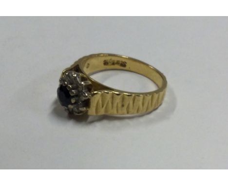 An 18 carat gold sapphire and diamond cluster ring. Approx. 5.5 grams. Est. £150 - £200.