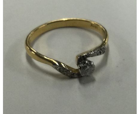 An 18 carat gold diamond crossover ring in claw mount. Approx. 3 grams. Est. £60 - £80.
