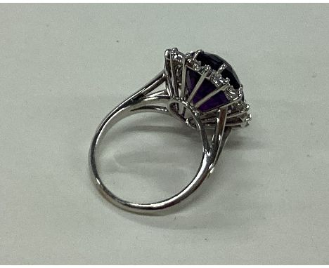 A large amethyst and diamond oval cluster ring inn 18 carat white gold claw setting. Est. £600 - £800.