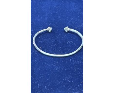 Sterling silver bangle with intricate detailing and finials, traditional design.