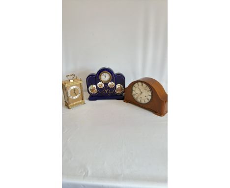 Wooden mantel clock with Roman numerals, from the 20th century. Brass carriage clock with ornate detailing and Roman numerals