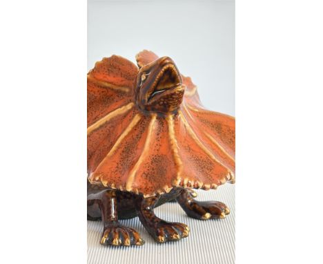 Frilled lizard figurine, detailed with a prominent frill and textured body. Material ceramic