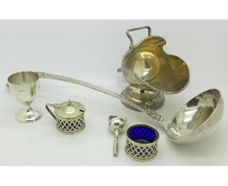 A silver egg cup, a plated ladle, sugar basin and condiments