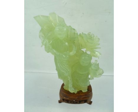 A CHINESE JADE CARVING, Bijin with companion, floral and tree trunk background, raised upon a polished carved wood stand, ove
