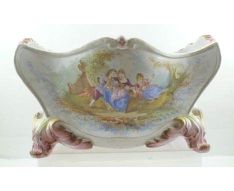 A FRENCH FAIENCE JARDINIERE PLANTER OF ROCOCO TROUGH FORM, raised on moulded acanthus leaf scroll feet, hand painted in paste