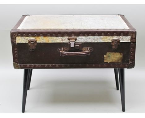 AN "UP-CYCLED" COFFEE TABLE constructed from an early to mid-20th century fibre and metal banded suitcase with leather handle