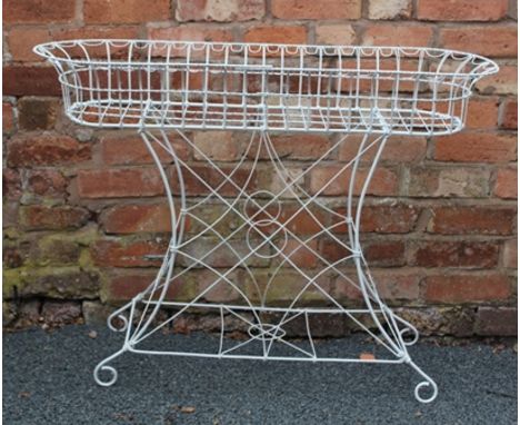 A VICTORIAN STYLE WHITE FINISHED WIRE WORK OVAL PLANTER STAND, supported on decorative frame with scrolling feet, 107cm wide 