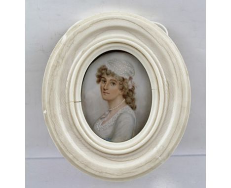 A 19TH CENTURY PORTRAIT MINIATURE, a bust length image of a young woman of fashion, a string of pearls about her neck, a Wate