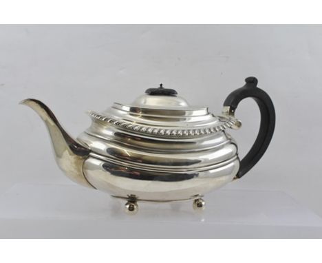 WILLIAM HUTTON & SONS LTD. AN EARLY 20TH CENTURY SILVER TEAPOT of Georgian design with gadrooned rim, on four ball feet, Shef