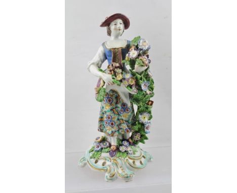 AN 18TH CENTURY BOW PORCELAIN FIGURE of a girl gathering flowers, holding them in her arm and apron, polychrome painted and g