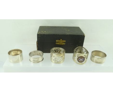A PAIR OF EPNS PIERCED NAPKIN RINGS, each with enamel crest for RMMV Capetown Castle and THREE OTHER WHITE METAL NAPKIN RINGS