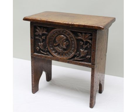 A 17TH CENTURY DESIGN SMALL OAK BOX COFFER OR BOX TOP STOOL, of plank construction, with hinged lid, the front deeply carved 