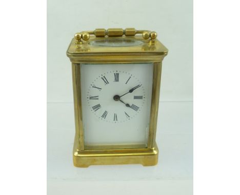 AN EARLY 20TH CENTURY FRENCH BRASS CASED CARRIAGE CLOCK with bevelled glass panels, white enamel dial with Roman numerals, fi