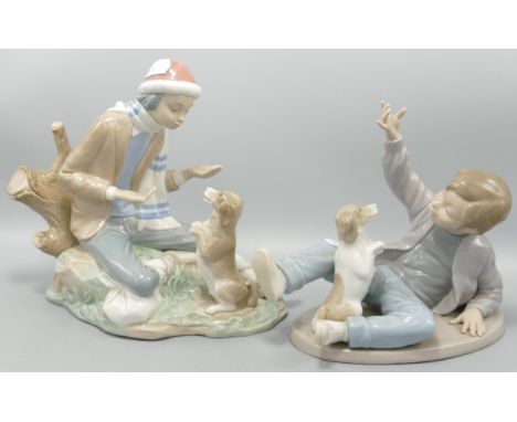 Two Nao figures of a boy playing with a dog . Height of tallest 20cm 