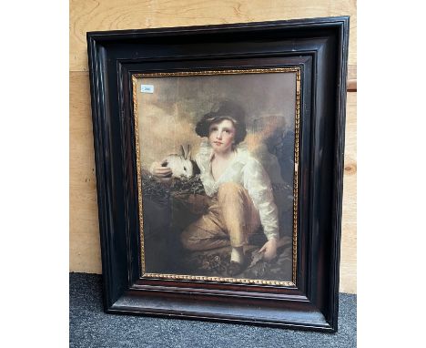 A Large vintage print of a young boy holding a rabbit. Fitted within a black frame. [85x71cm] 