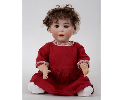 A CUNO & OTTO DRESSEL BISQUE SOCKET HEAD DOLL with a curled brown wig, sleeping grey glass eyes, and an open mouth with tremb