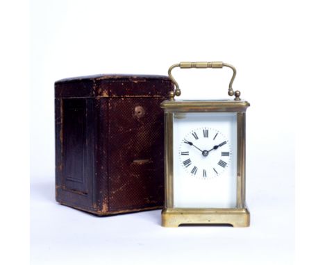 A 19th century French brass carriage timepiece, with white enamel dial, on bracket feet, 11.5cm high, in original leather out