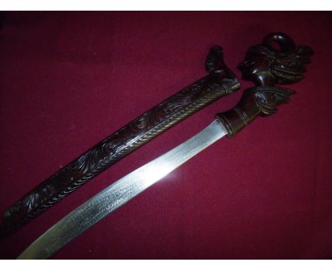 Malaysian Parang sword with carved wooden scabbard and hilt in the form of a Waygang character, with 15 inch blade 