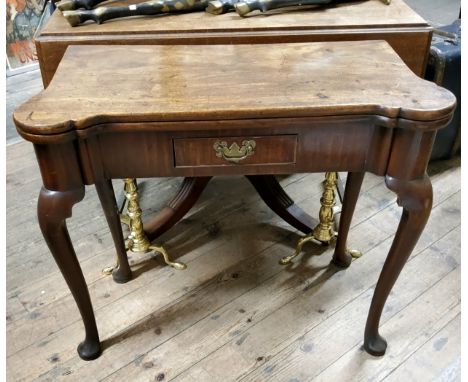 A George II period card table of Chippendale design, with a hinged top of shaped outline above the shaped apron fitted with a