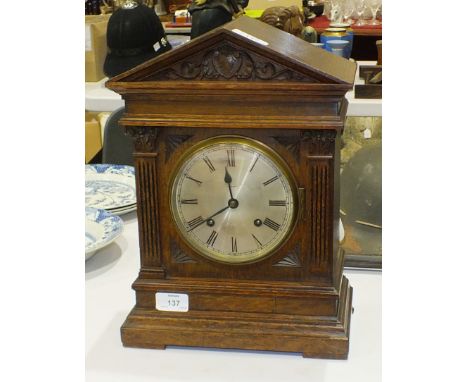 An oak-cased striking mantel clock of architectural design, the dial marked Masons, Middlesbrough, 36.5cm high.