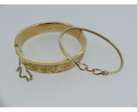 A 9ct yellow gold Hinged Bangle, the front with foliate engraved decoration, 18.8g, together with a narrow 9ct gold bangle, t