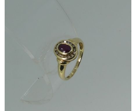 A 9ct yellow gold Ring, the circular front set with a central facetted oval ruby, with a surround of small diamond points, Si