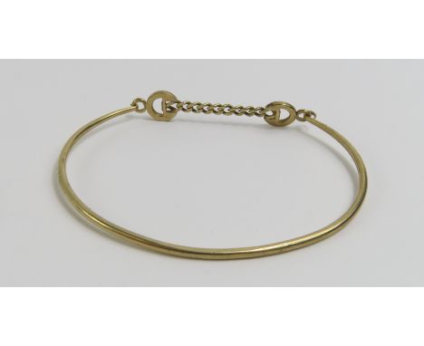 A 9ct gold bangle with a chain link fastening to the centre, 4.9g gross