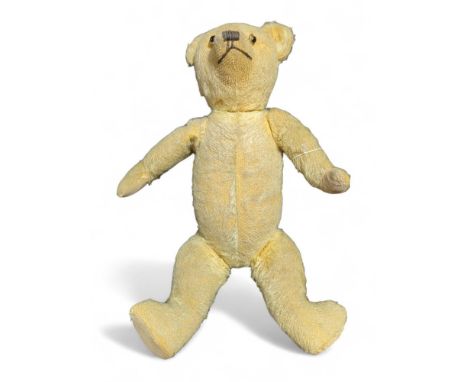 An early 20th Century teddy bear with golden plush, replacement button eyes, stitched nose and mouth and cotton pads, 47cms h