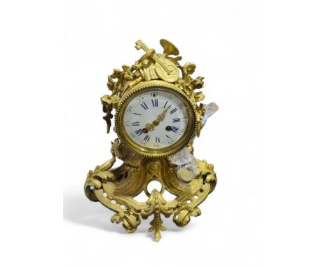 A mantel clock in rococo style brass case and having white enamel dial with blue numerals, striking on a bell 33cms high