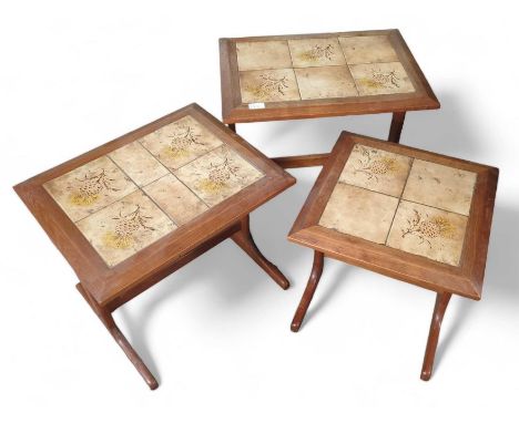 A nest of three mid-20th century tile top teak tables