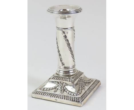 An Edwardian silver candlestick embossed with husk swags and with square weighted base, 12.5cms high