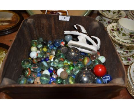 A wooden box containing a large amount of vintage marbles.