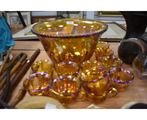 A large 1930s Bubble glass punch bowl and eleven matching cups, in iridescent orange having fruit design.