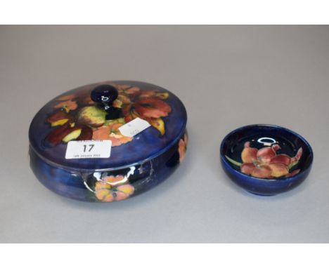 Two pieces of vintage Moorcroft, a lidded pot having blue ground with orchid design(AF) and a similar pin dish.