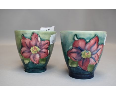 Two vintage Moorcroft beakers having green ground and clematis pattern in pink.