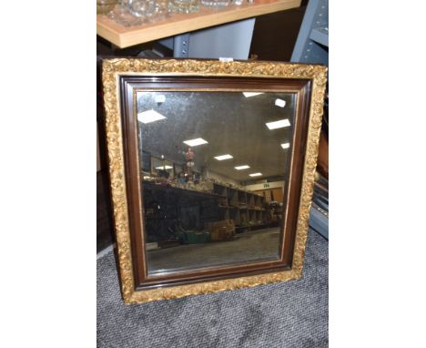 A vintage wooden framed mirror having gilded floral decoration.