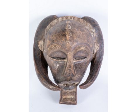 African art Mask with horns, LubaD.R. Congo. . Cm 28,00 x 34,00. dark patina wood with white highlights. Male face framed by 