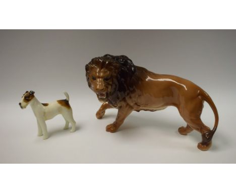 A Beswick ceramic model of a lion, 29cm long; a Royal Doulton model of a Fox Terrier (2)