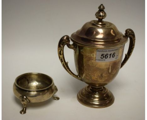 A George V silver two-handled pedestal trophy cup and cover, acanthus grasped scroll handles and knop finial, domed circular 