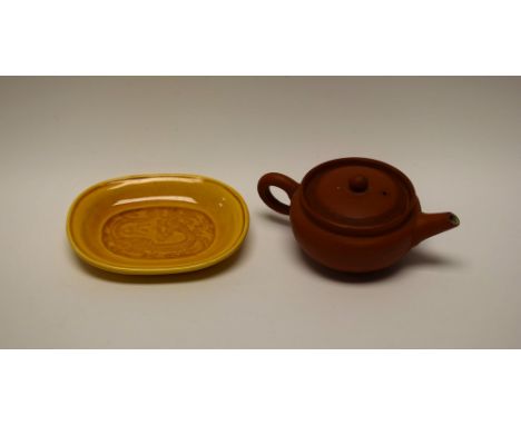 A Chinese Yixing terracotta teapot, 11cm long; a Japanese Awaji yellow monochrome high-fired stoneware dish, in relief with a