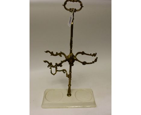 A 19th century gilt-metal table-top wine bottle stand, the central post with sprung mechanism, ceramic base, cast throughout 