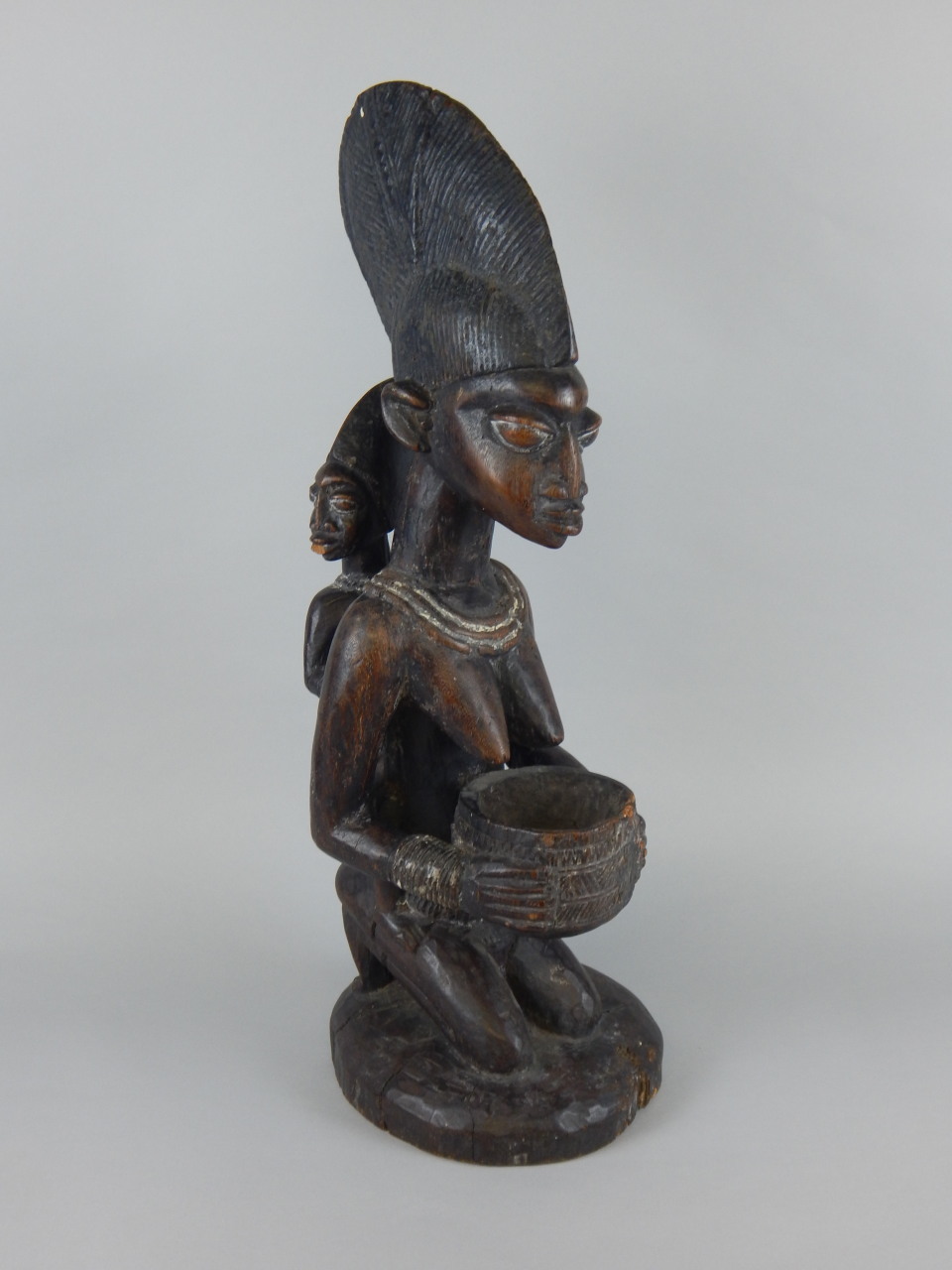Tribal Art. An African carved wooden figure, in the form of a kneeling ...