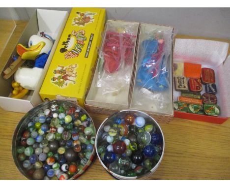 A mixed lot to include a boxed Donald Duck Pelham puppet, two boxed dolls, gramophone needle tins and a selection of marbles 