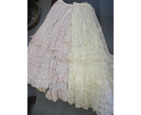 A vintage blue suitcase containing four straw bonnets, early 20th century full length ladies skirts, one being a lace example